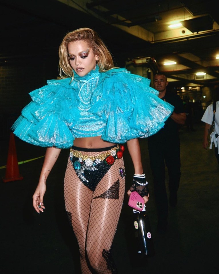 Rita Ora embraces the stylish stockings with a blue tulle top and black pants