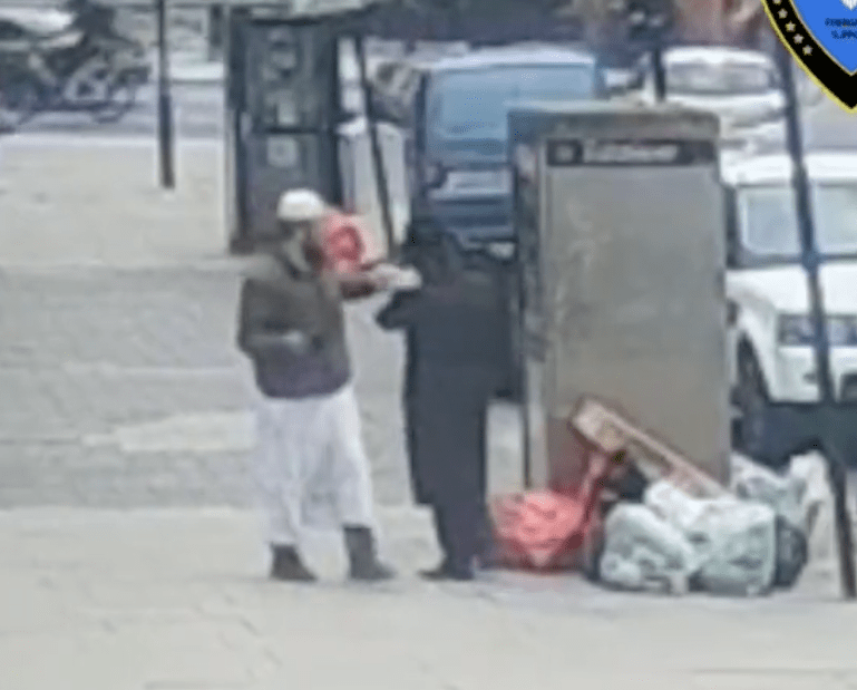 A man appears to strike a passerby in the face with a bottle