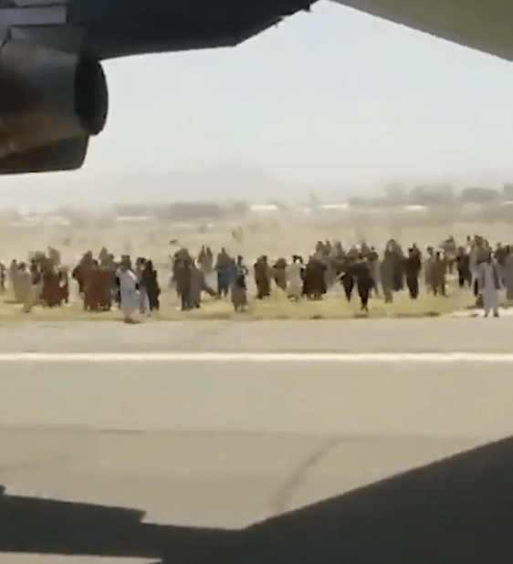 As the plane carrying the Afghan stowaways takes off, people down below can be seen apparently cheering