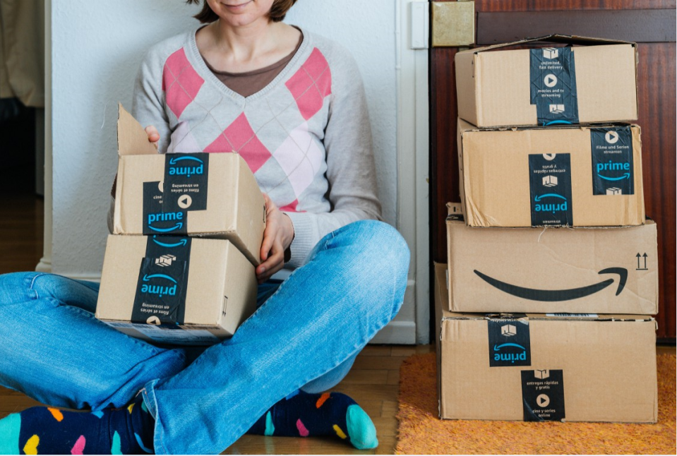 Person holding Amazon Prime boxes.