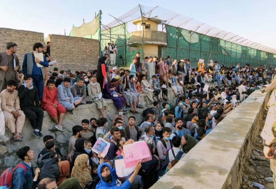 Crowds of people wait outside the airport in Kabul, Afghanistan today, desperate to get on an evacuation flight