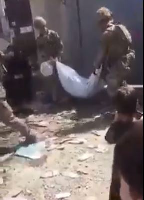 Soldiers carry body bags after the horrifying scenes