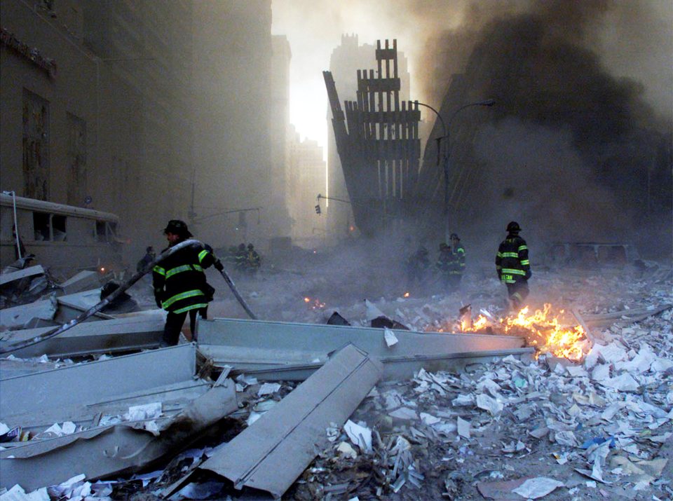 Firemen survey the smouldering remains of New York’s Twin Towers