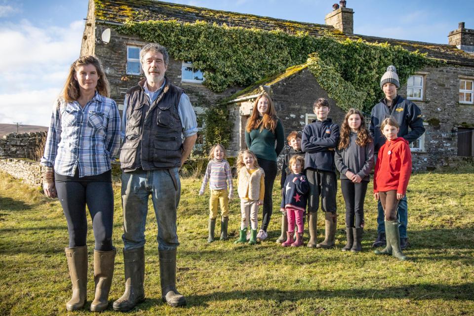 Amanda and Clive with their nine children outside the farmhouse