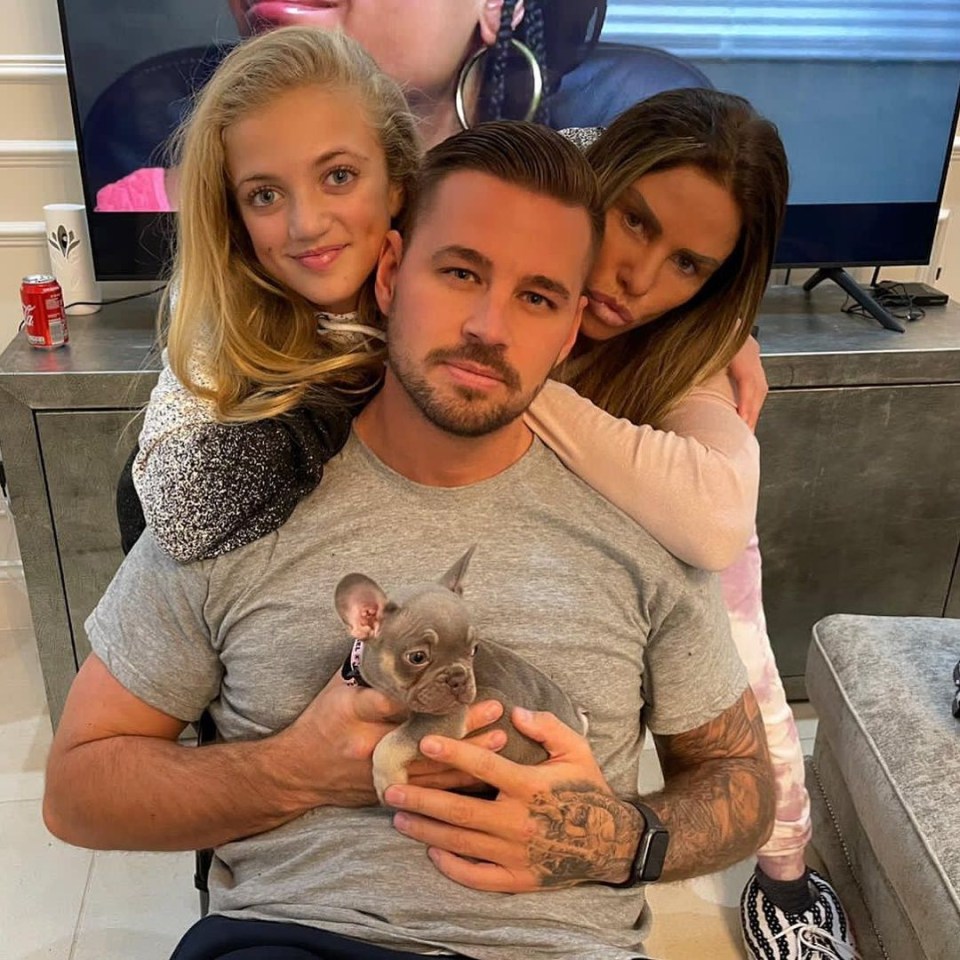 Katie Price and fiance Carl Woods pose with Katie's daughter Princess and her dog Precious last summer