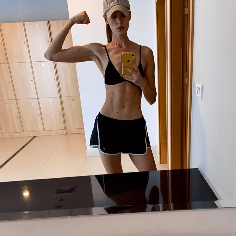 Sian flexes her muscles in the mirror