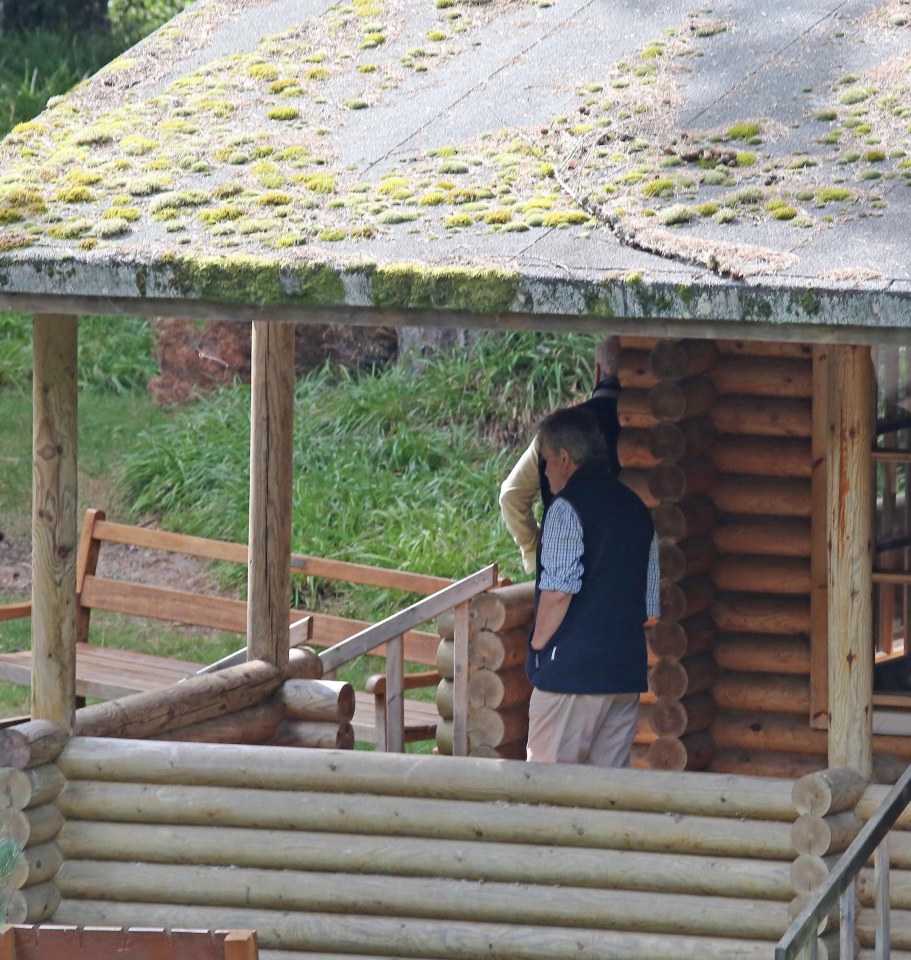 The back of Prince Andrew's head is just visible as he quickly disappears inside the fishing lodge