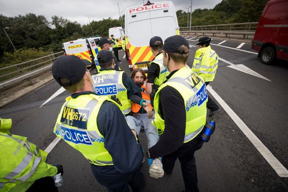 A protester is arrested by police after being removed form the road