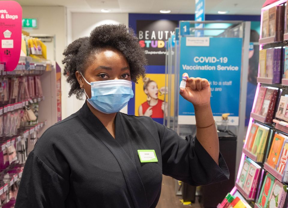 Pharmacist Siphiwe Chungu holds the vial of the first Covid booster to be given in high streets at Superdrug in Leeds as the third jab rollout begins