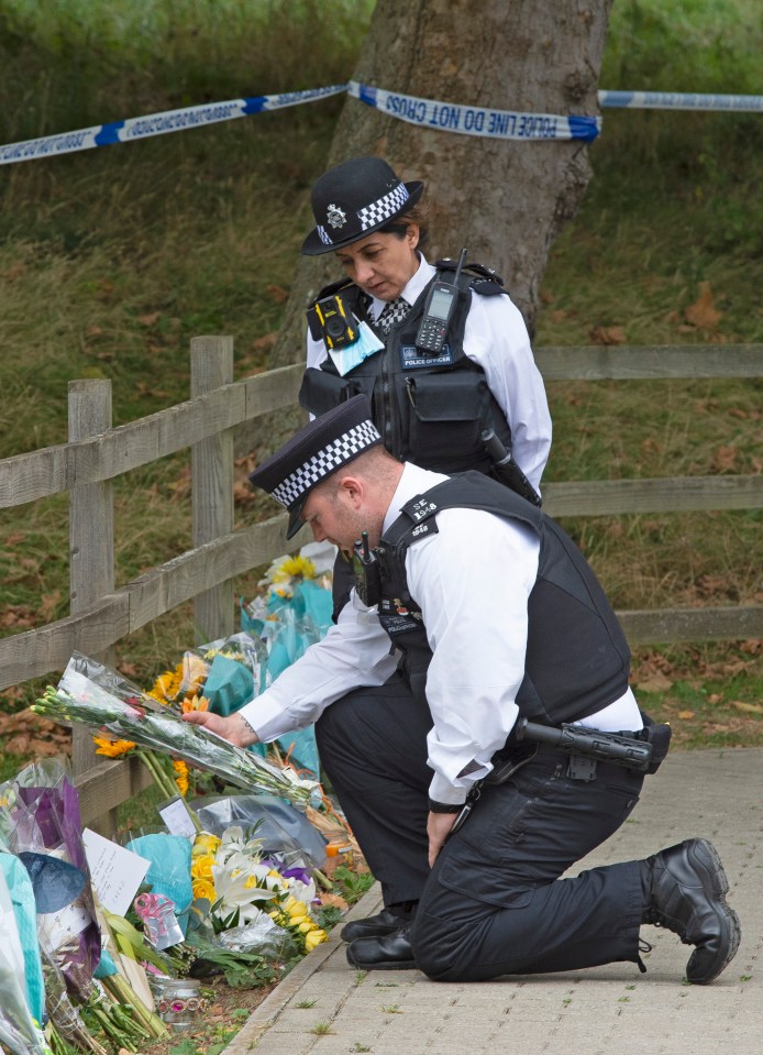 Officers laid flowers from mourners at the scene of the crime