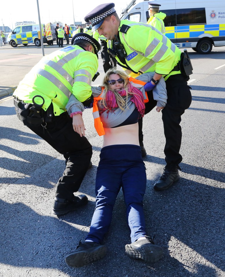 A resistant protester is dragged away from the A20