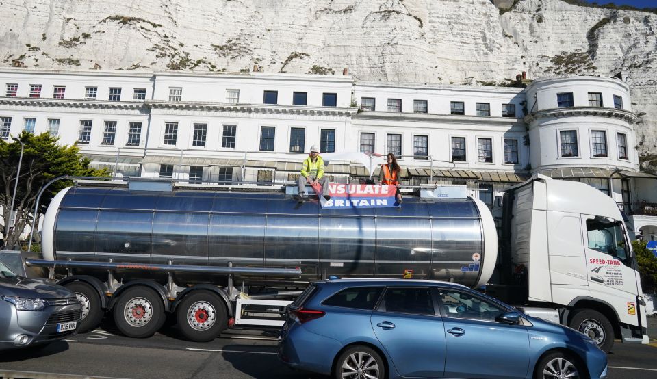 Protesters from Insulate Britain sit on top of a tank in Kent