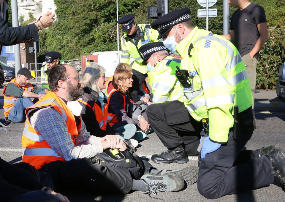 Cops speak to protesters sitting in the middle of the road