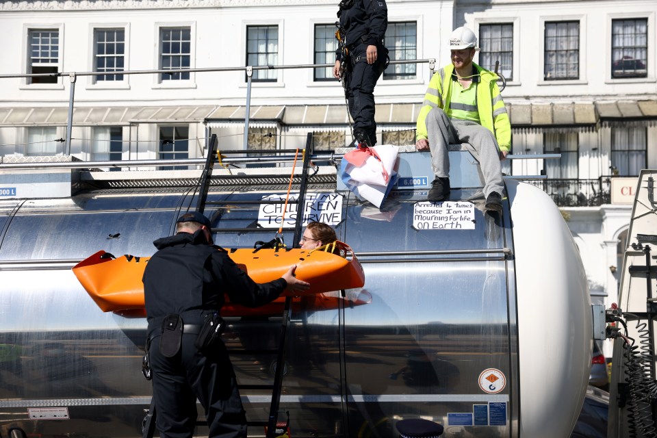 Police officers remove a protester from the roof of a lorry at the entrance of Port of Dover