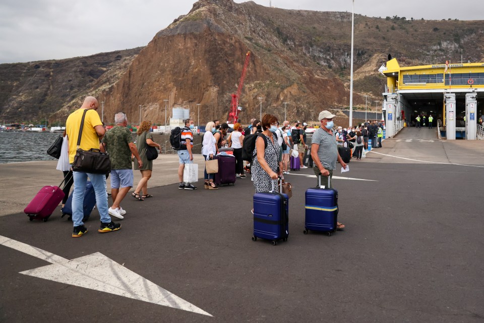 Tourists wait for the ferry to leave the island after La Palma Airport was closed