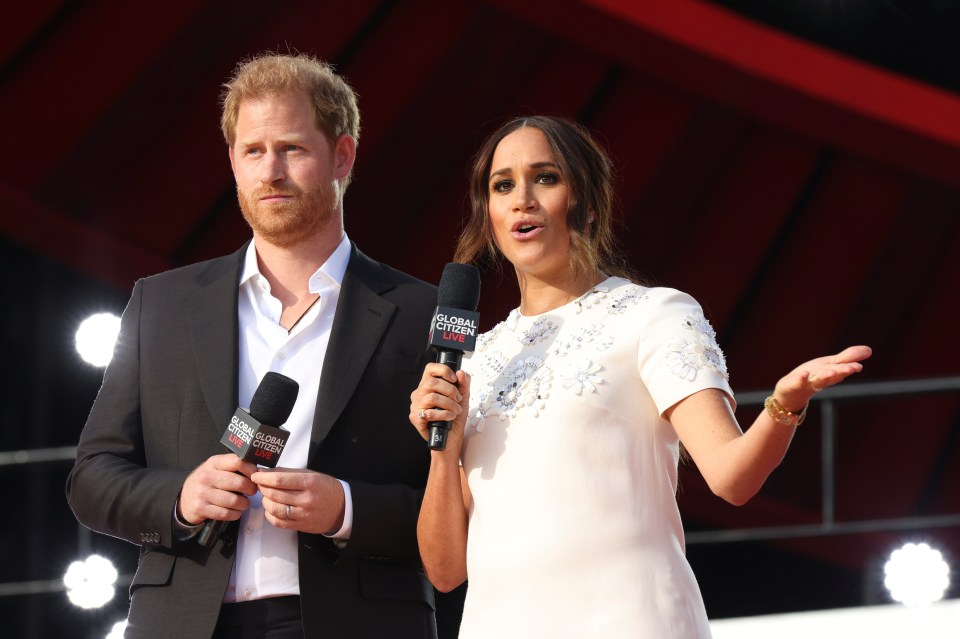 Meghan helps Harry get the message across to the cheering crowd at the Global Citizen gig