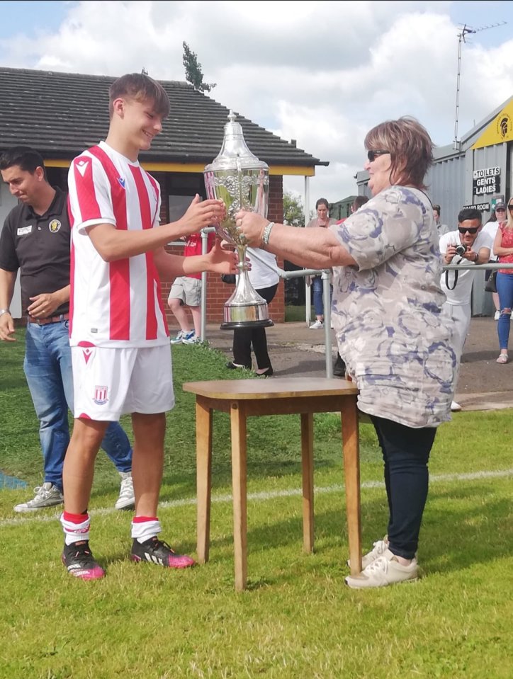 Captain Tezgel receives the Don Hill Memorial Trophy after Stoke City beat Rocester FC 3-2