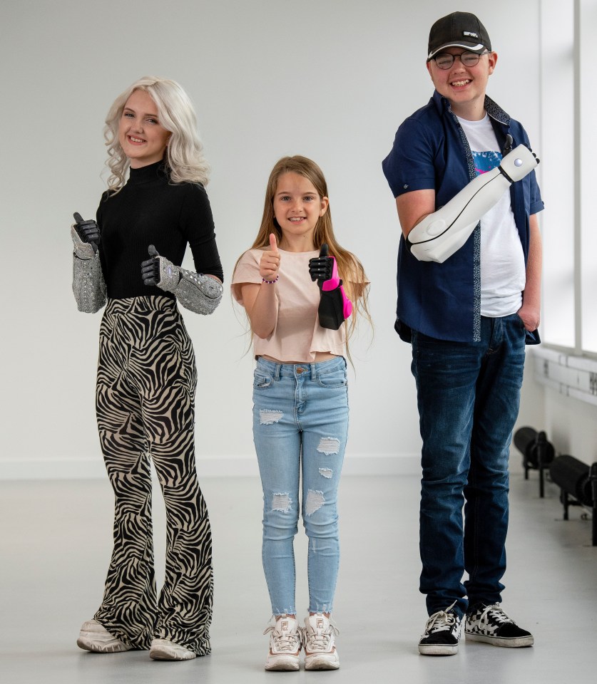 Joel Gibbard MBE (right), a robotics expert, and Samantha Payne MBE (left) are pictured above with Phoebe (centre)