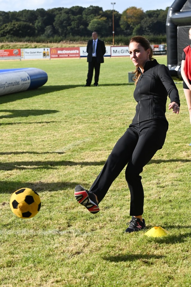 Kate kicks a football during a visit City of Derry Rugby Club