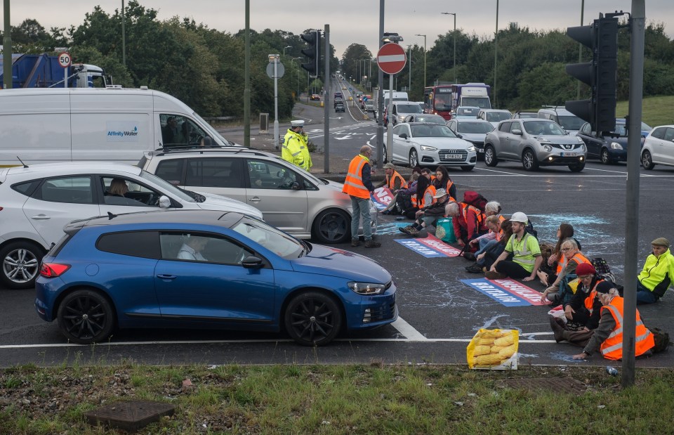 Activists prevent motorists from driving as they are stuck to the road