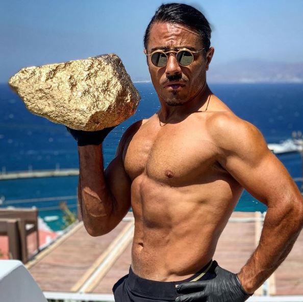 Nusret holding a hunk of meat covered in gold on the Greek island of Mykonos, where he has a restaurant