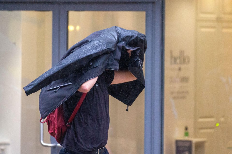 A shopper on a wet and windy day in Preston, Lancashire