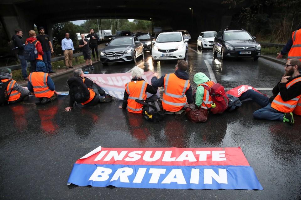 Activists brandish banners reading 'Insulate Britain'