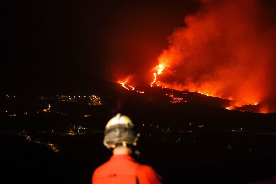 Rescue workers watch on as the volcano continues to erupt