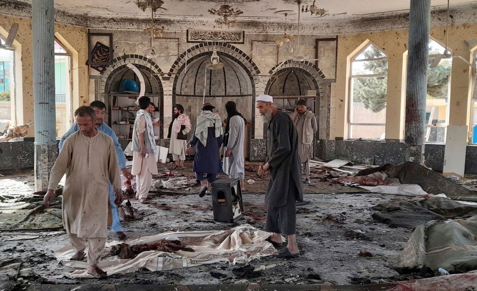 Local men view the horror inside of a mosque following a bombing in Kunduz