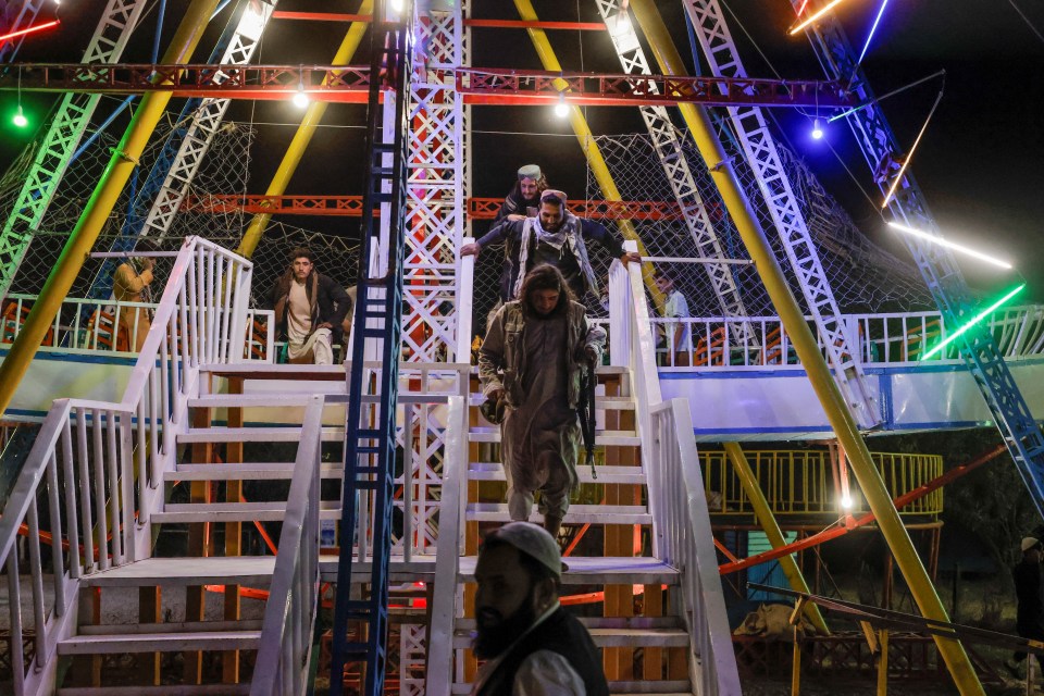 Taliban fighters climb off a theme park ride as they shamelessly enjoy themselves