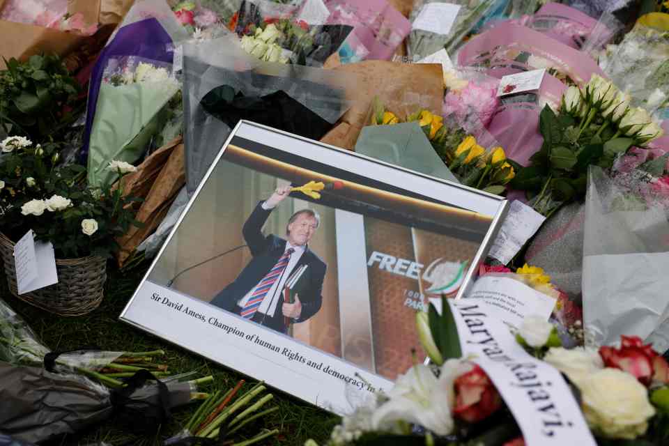 A photograph of Sir David smiling broadly and holding aloft a rose was marked 'champion of human rights and democracy'