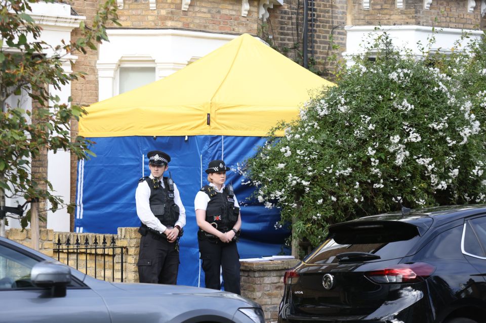 Officers today outside the home of a man suspected of murdering Sir David