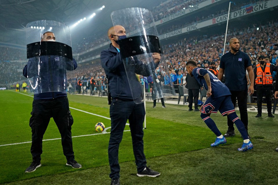 Neymar takes a corner under the protection of police shields