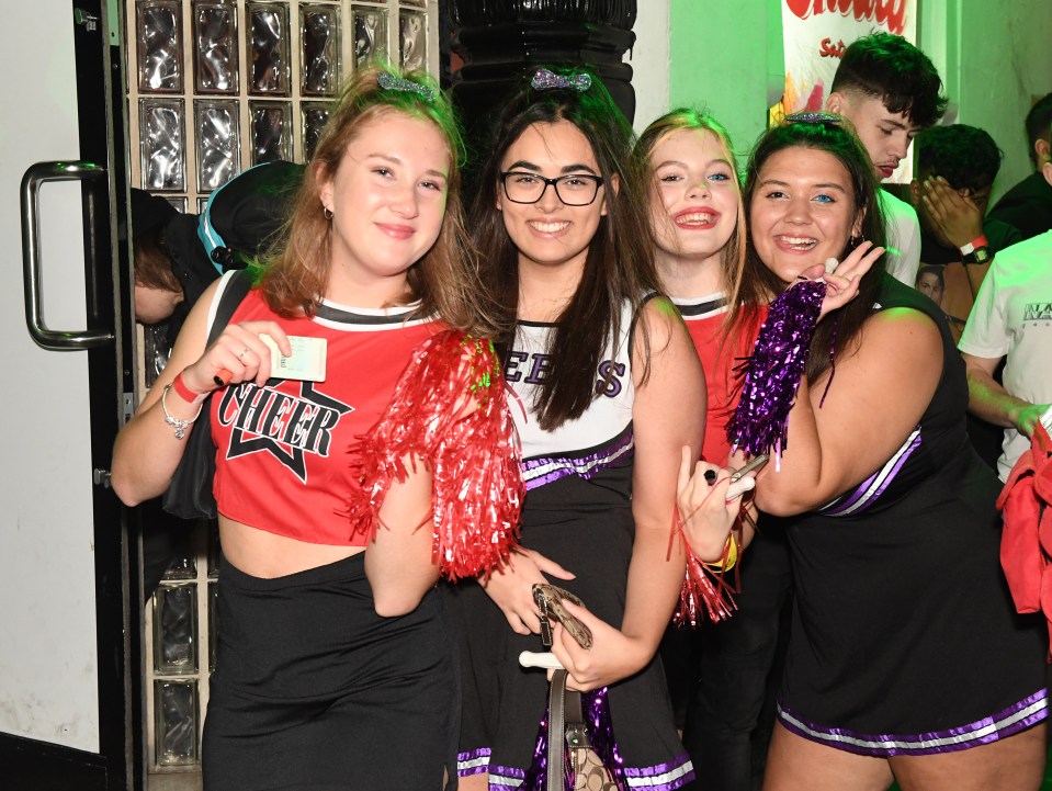 Friends in fancy dress pose as they queue up to get in