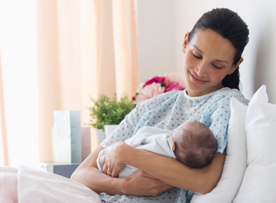 BNWWA1 Mother holding newborn baby in hospital bed. Image shot 2010. Exact date unknown.