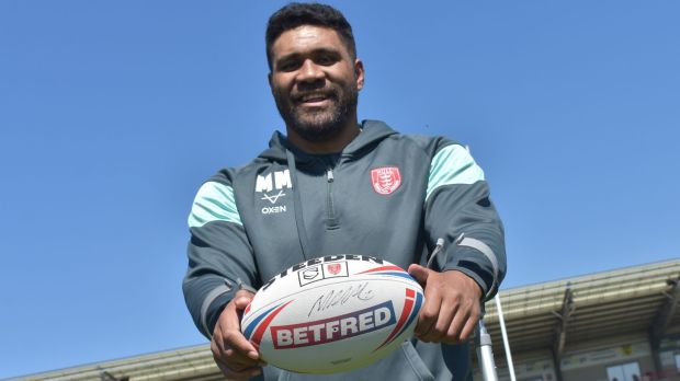 a man holding a rugby ball that says betfred on it