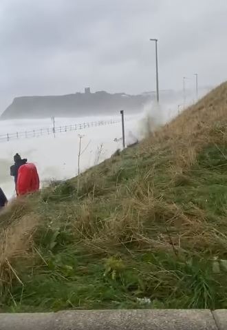 A man battles through a huge wave on the Scarborough coast