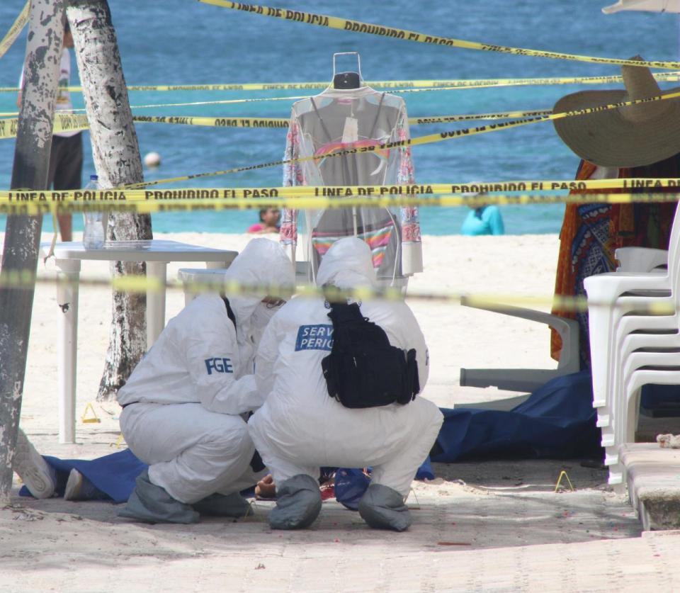 Forensics officers at Cancun's Tortuga Beach where a US tourist was wounded in a cartel shooting in June