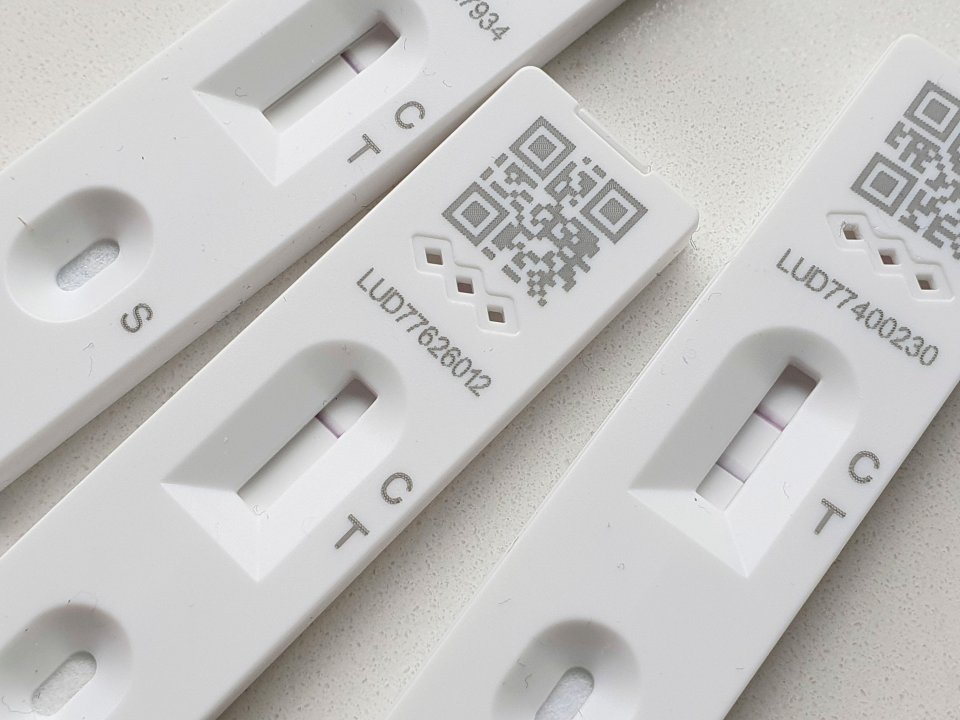 Negative (left/centre) and positive (right) lateral flow test results