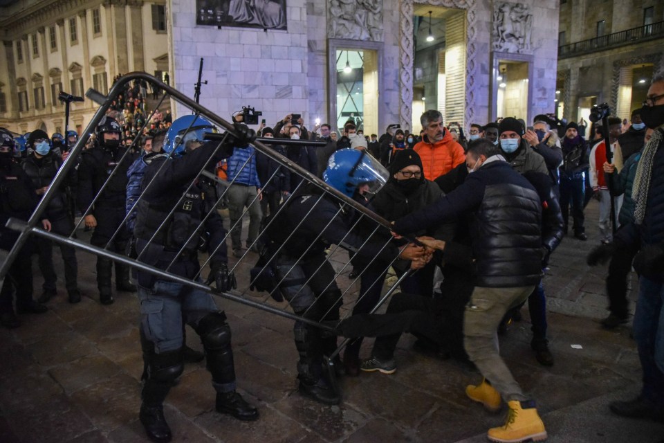 Police and demonstrators clash during a protest in Milan against vaccine passes