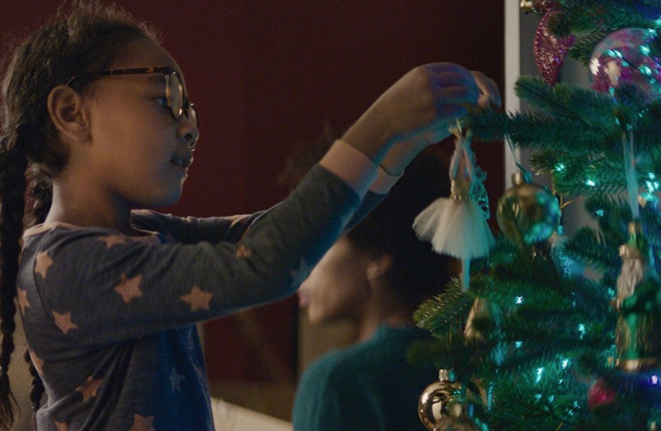 Nathan's little sister decorates the tree with their family