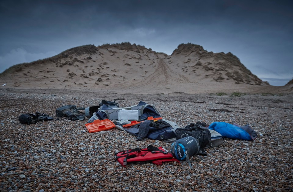 Belongings of migrants, along with a deflated dinghy, life jacket and engines, lie on the beach of Wimereux in Calais, France