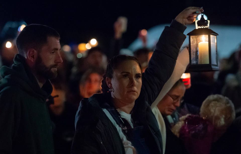 A woman holds a candle in memory of Bobbi-Anne