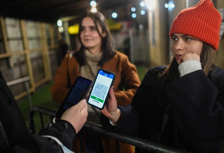 A woman showing a Covid passport to enter a night club in Scotland, where it's already compulsory