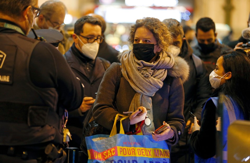 A passenger wearing a protective face mask waits to board a train at Gare de Lyon in Paris