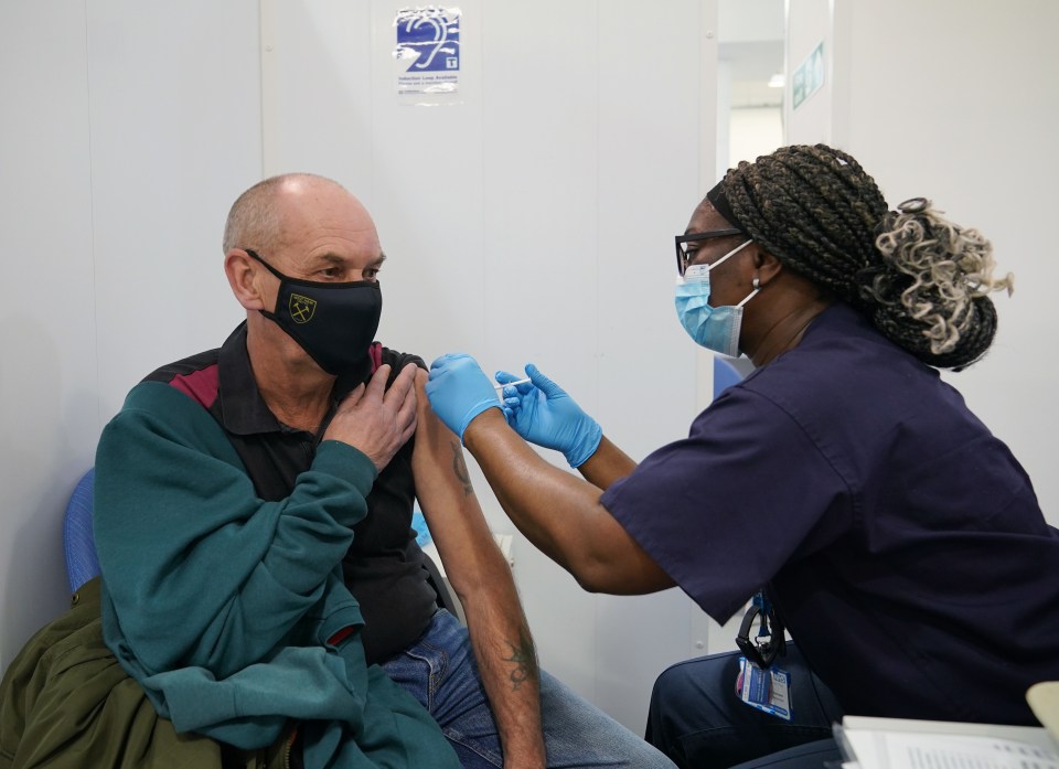 A member of the public gets a booster at the vaccination site in Liberty Shopping Centre, Romford, December 2