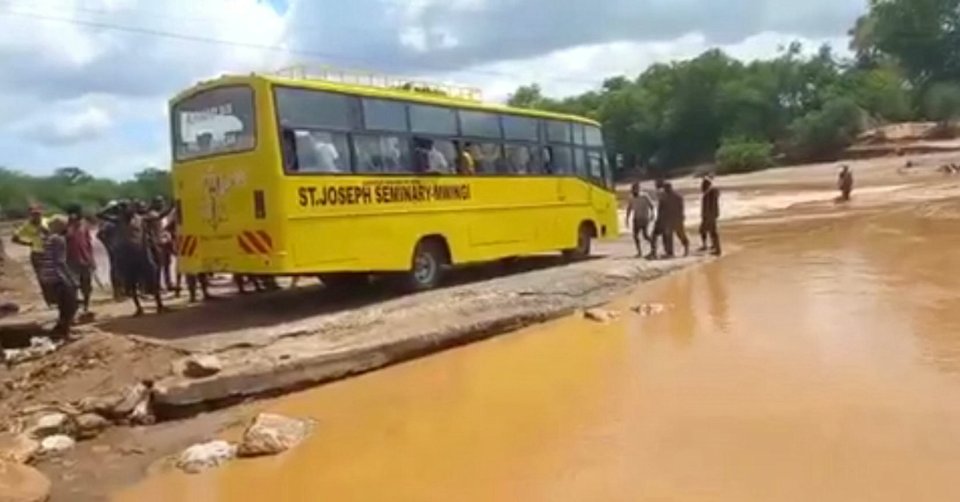 The yellow school bus came across a flooded road with rapidly-flowing water