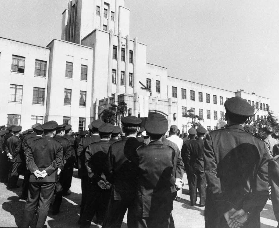 Japanese soldiers watch as Mishima attempts to inspire them to overthrow the army