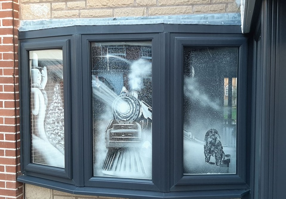 The unique festive window art is made using spray-on snow