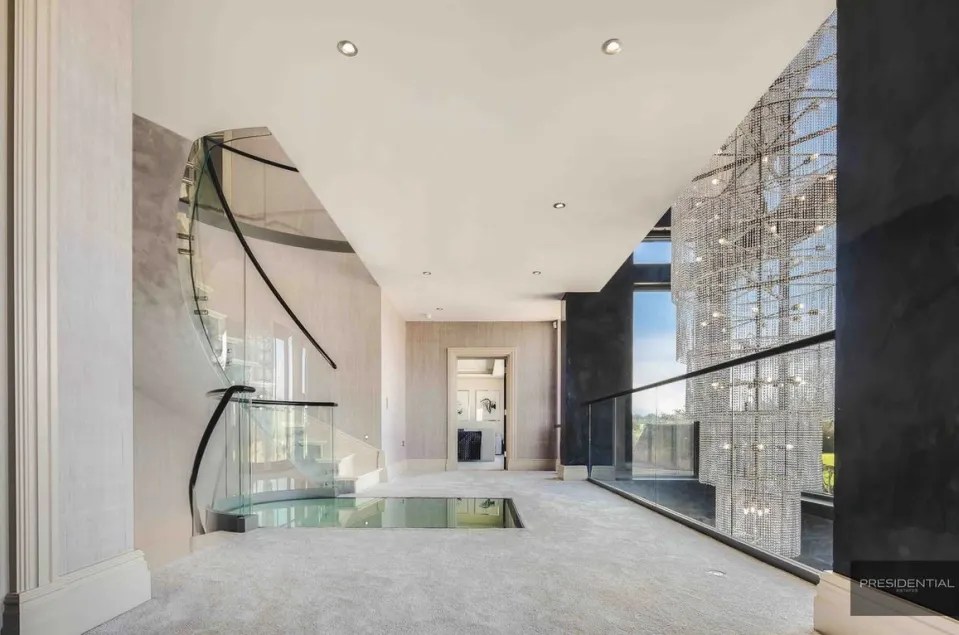 A stunning stone and glass staircase leads up to the bedrooms